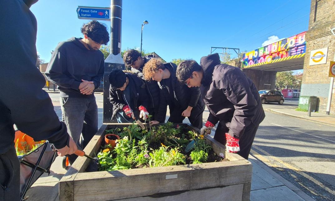 Group of young people looking at a small garden patch