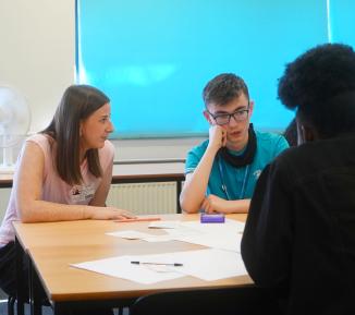 A UOK? trainer talks to students during a workshop