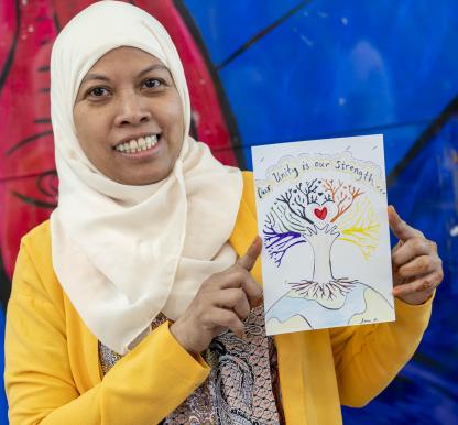 A woman holds a handmade postcard