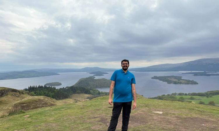 A photo of Osama, the writer of this blog, stood outside in nature with lakes in the background