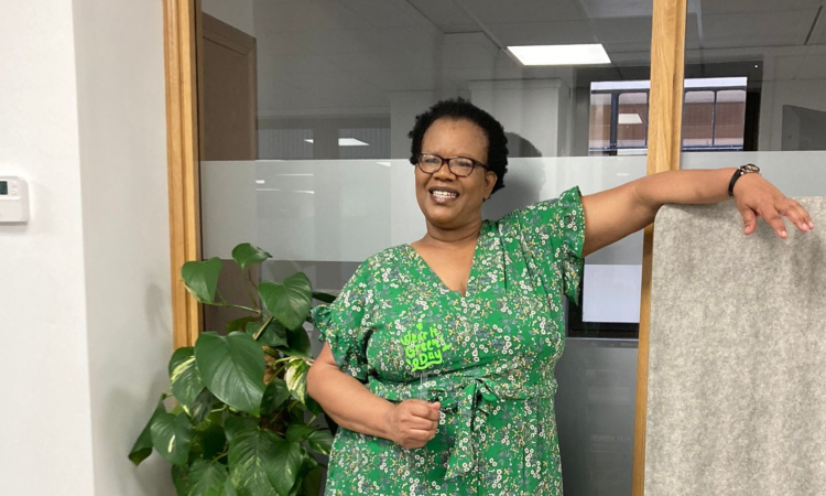 A photo of a smiling Menesia, wearing green for Wear It Green Day