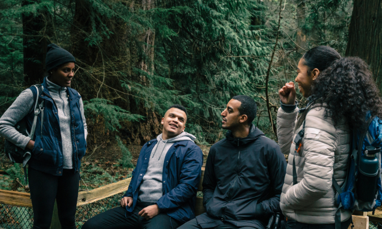 A group of young men and women on a hiking trip in the woods