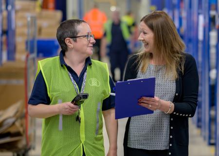 Two women working in a warehouse or a factory